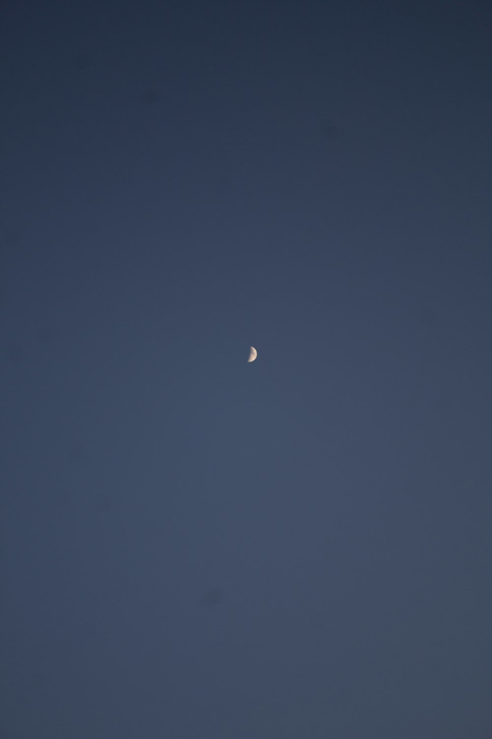 a half moon is seen in the night sky