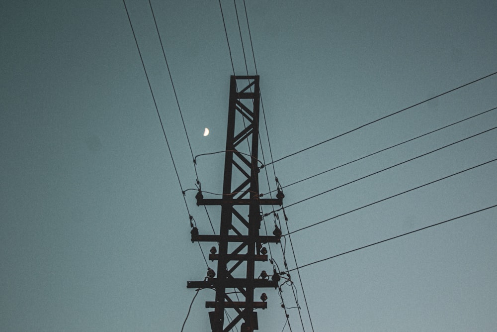 a telephone pole with a full moon in the sky
