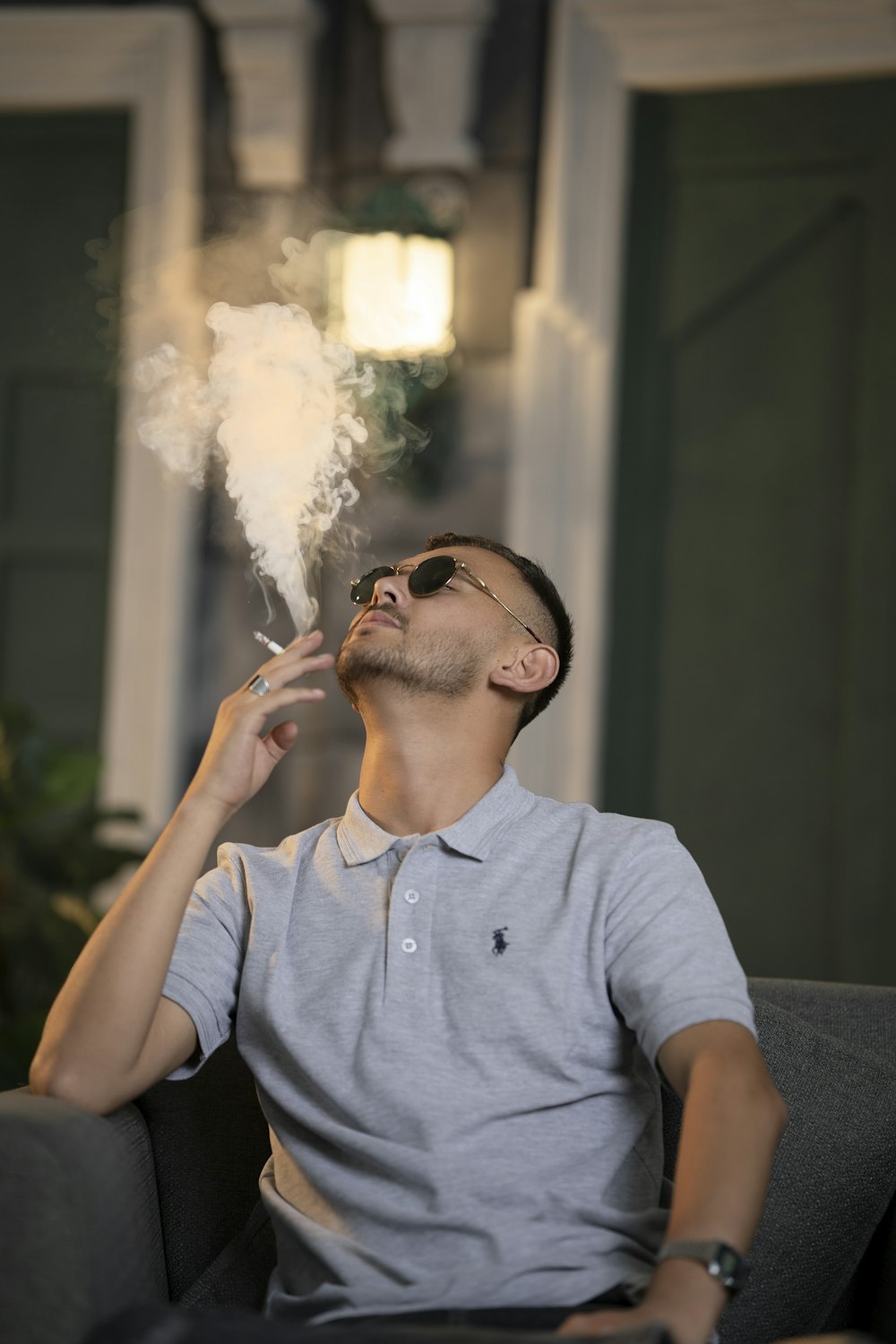 a man sitting on a couch smoking a cigarette
