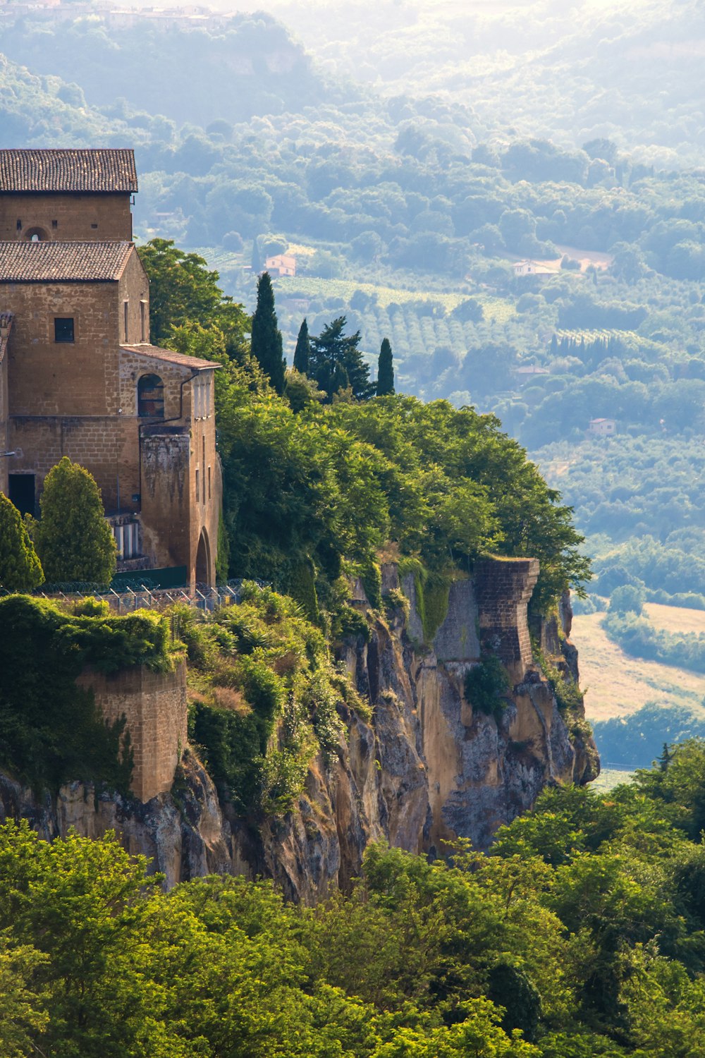 a castle on top of a mountain surrounded by trees