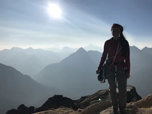 Sunset view of a climber reaching the summit with gear from Cumbreviva