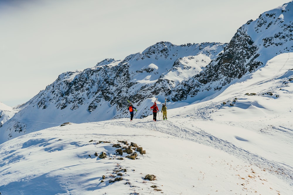 a group of people standing on top of a snow covered mountain