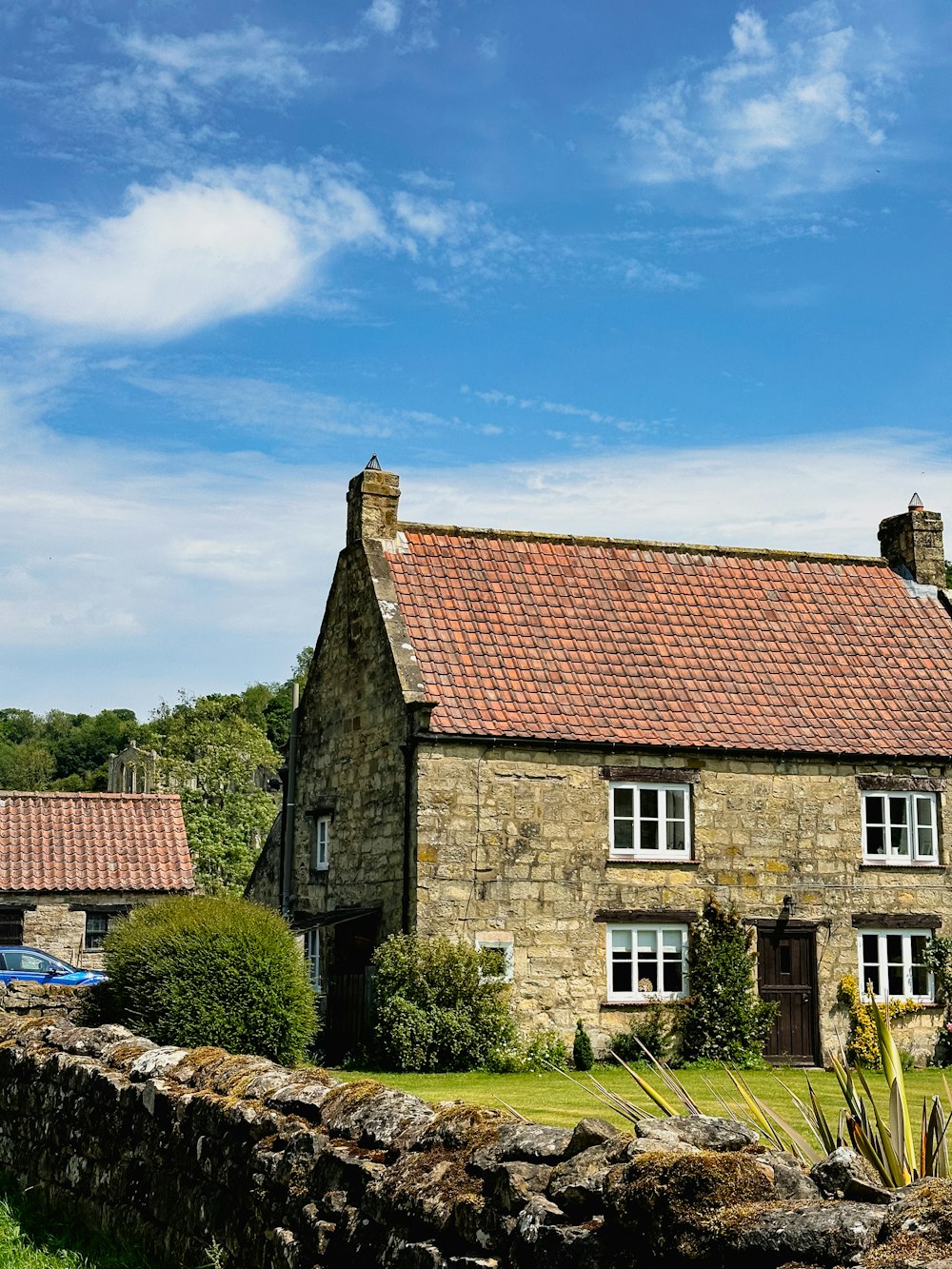 a stone house with a red tiled roof