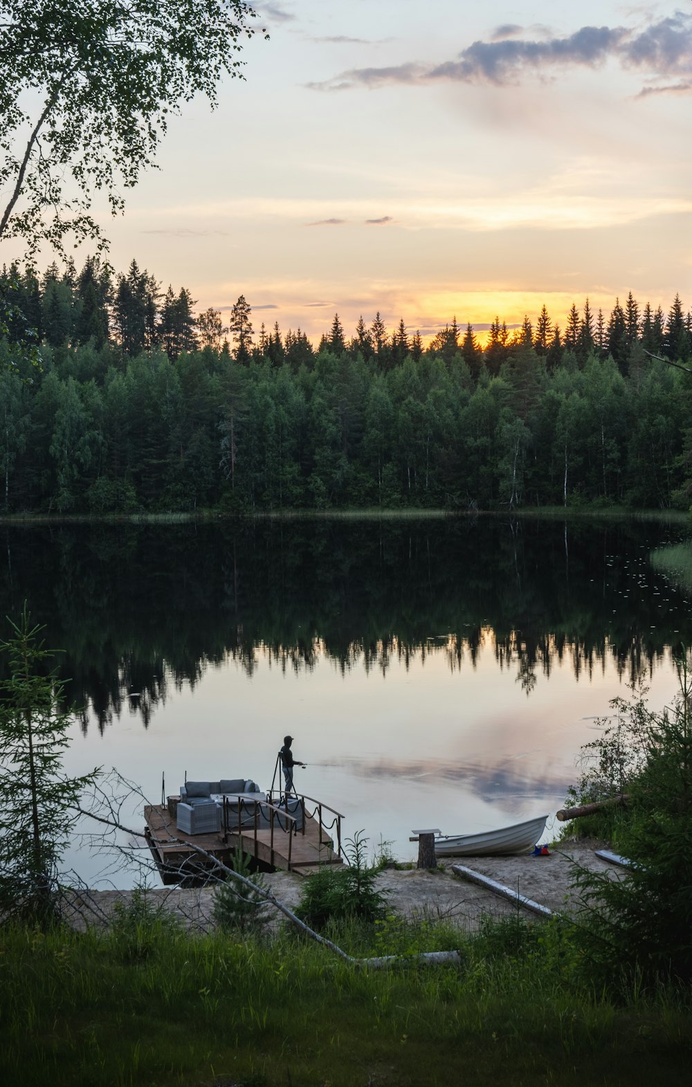 a boat sitting on top of a lake next to a forest