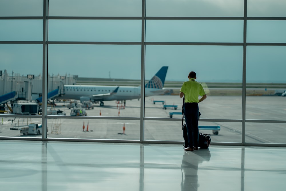 a man standing in front of an airport window