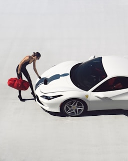 a man standing next to a white sports car