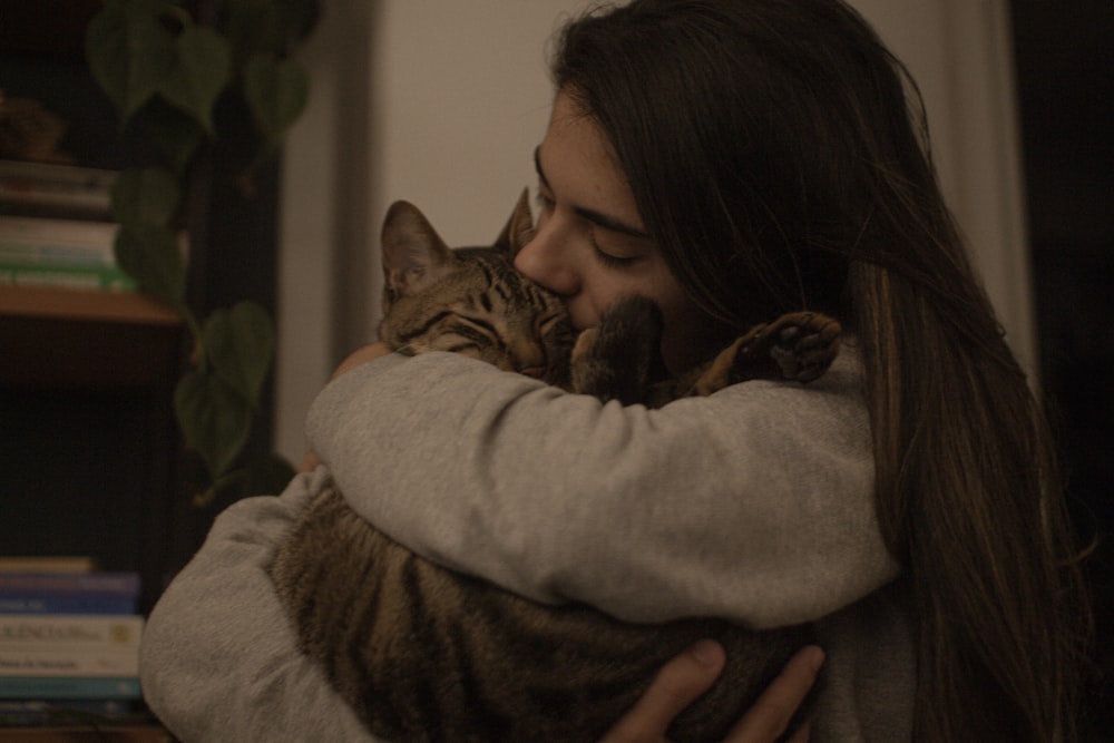 a woman holding a cat in her arms