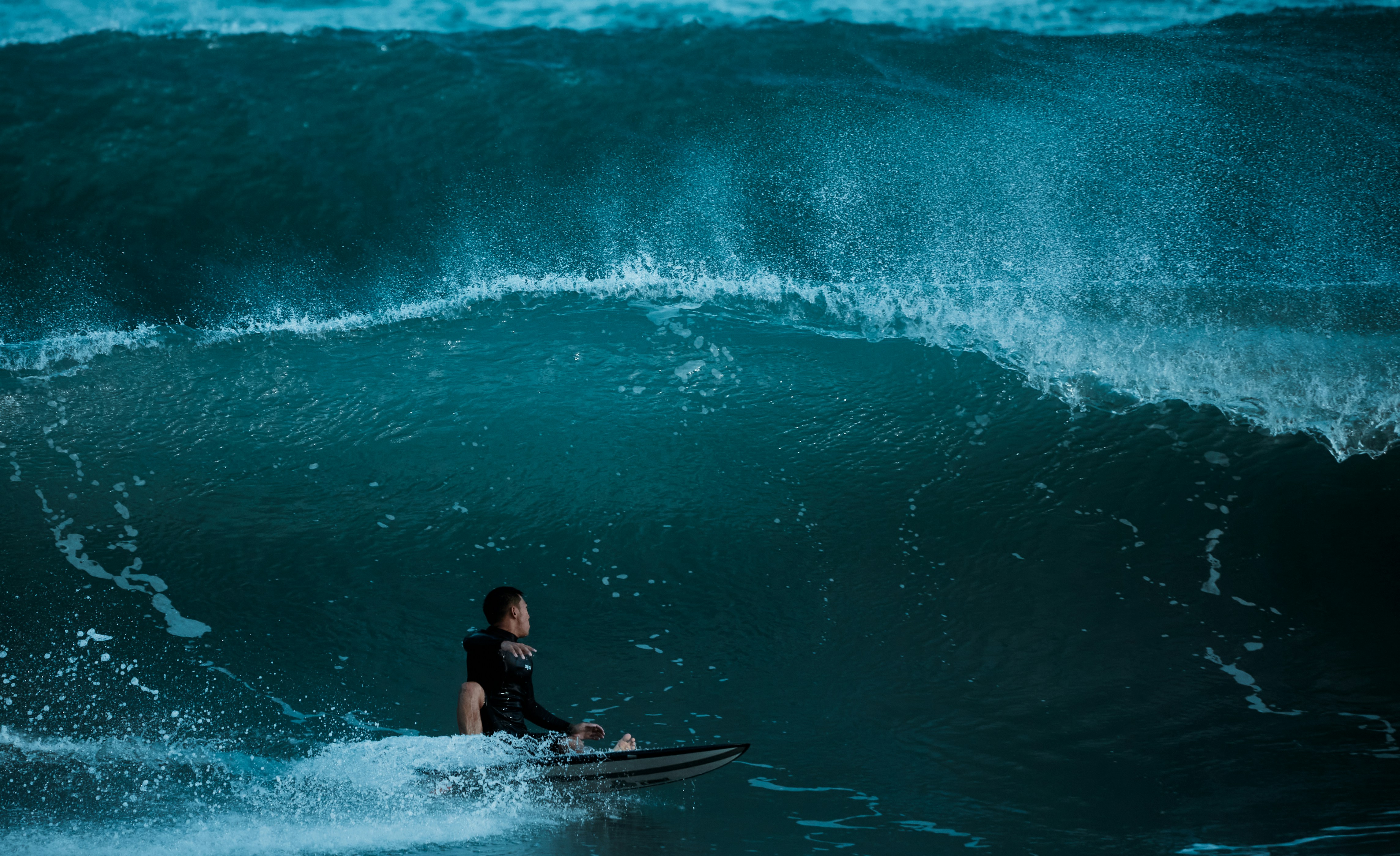 a man riding a wave on top of a surfboard