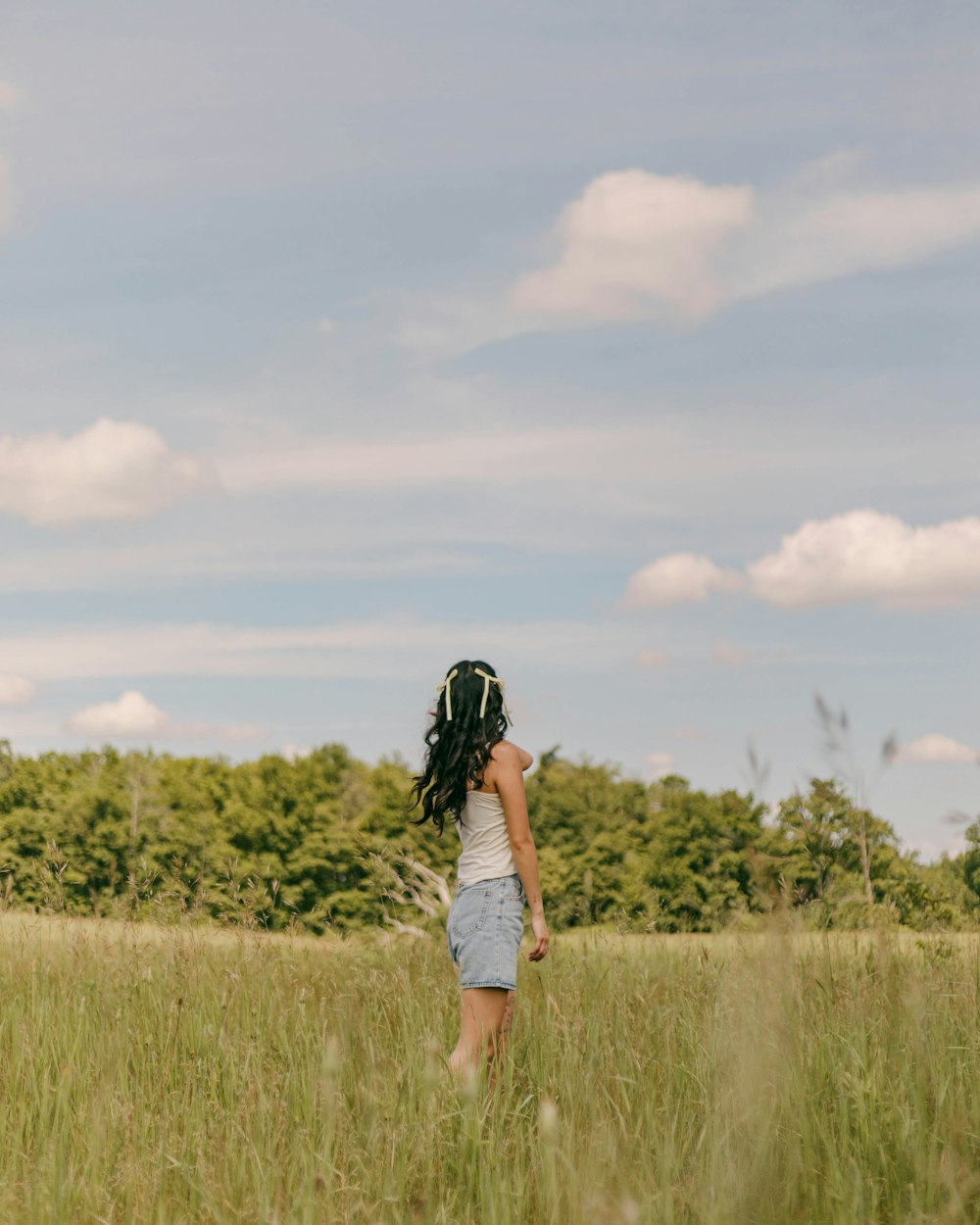 a woman standing in a field of tall grass