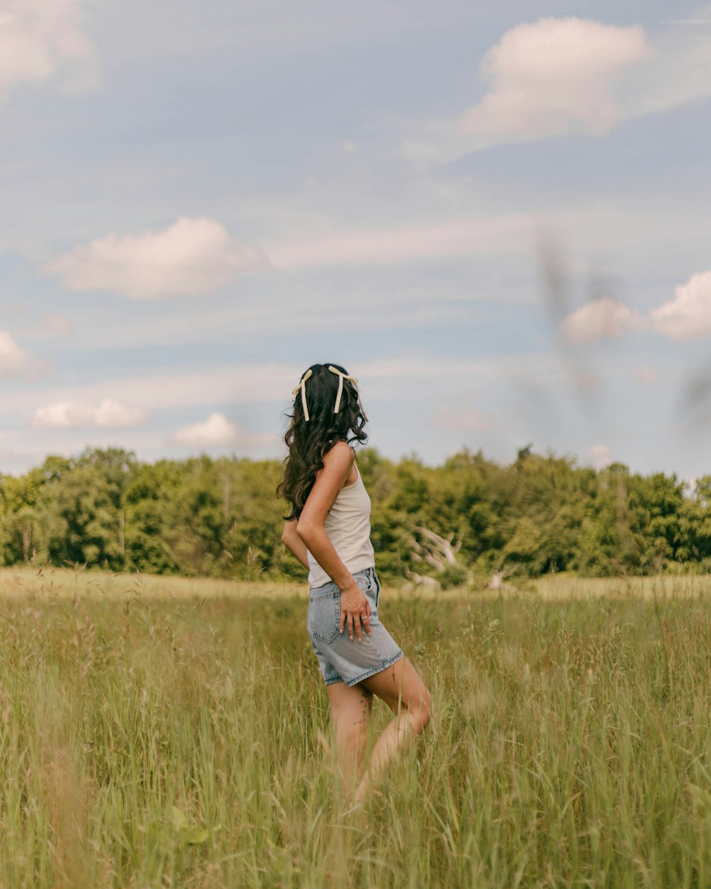 a woman standing in a field of tall grass