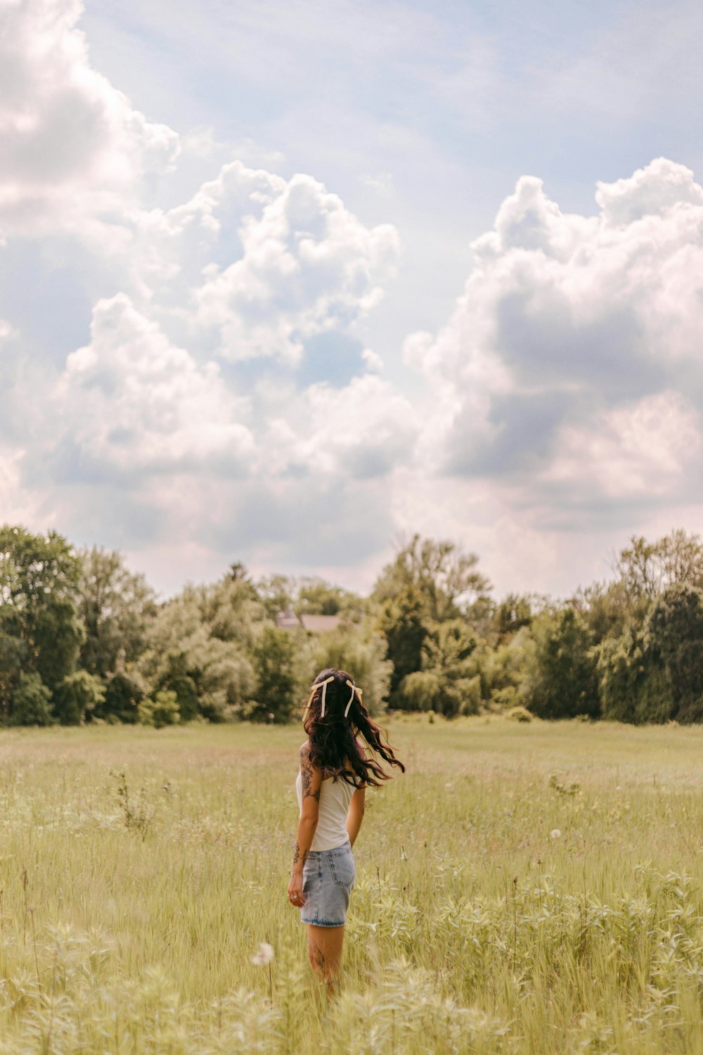 a woman standing in a field of tall grass