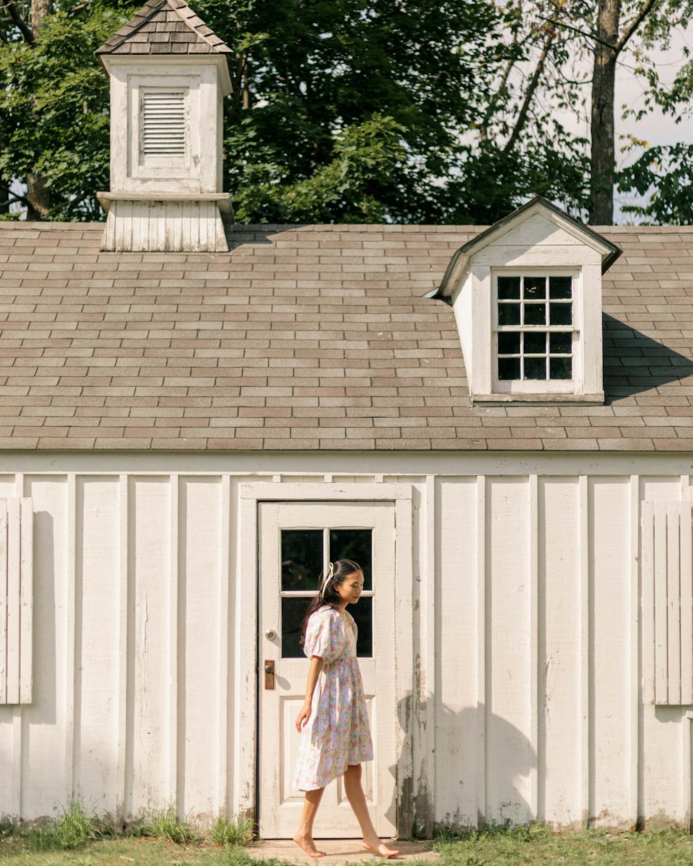 a woman standing outside of a white building