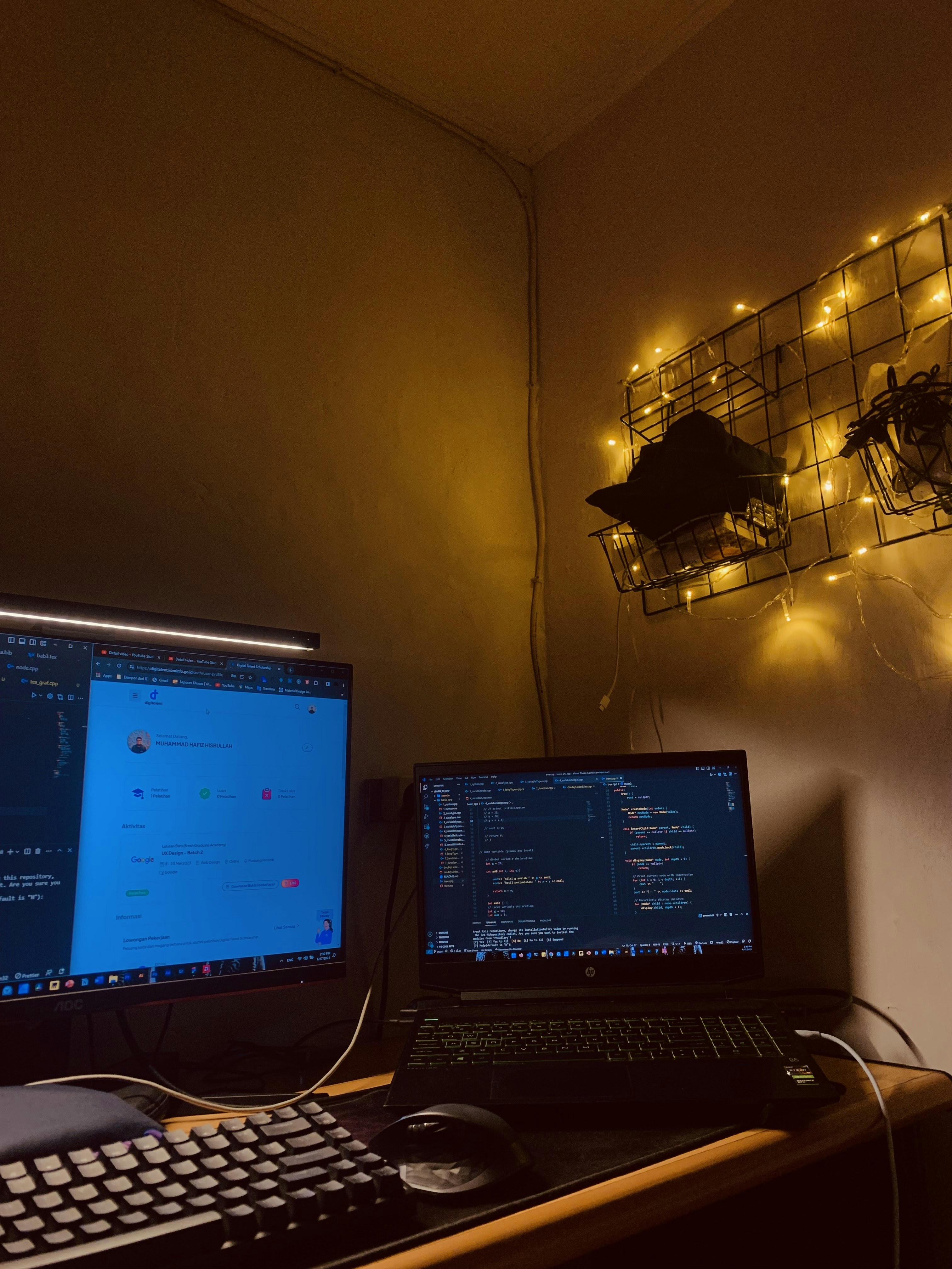 Bright well-lit workspace with code on multiple screens, open laptop, natural window light