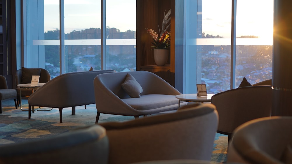 a living room filled with furniture and tall windows