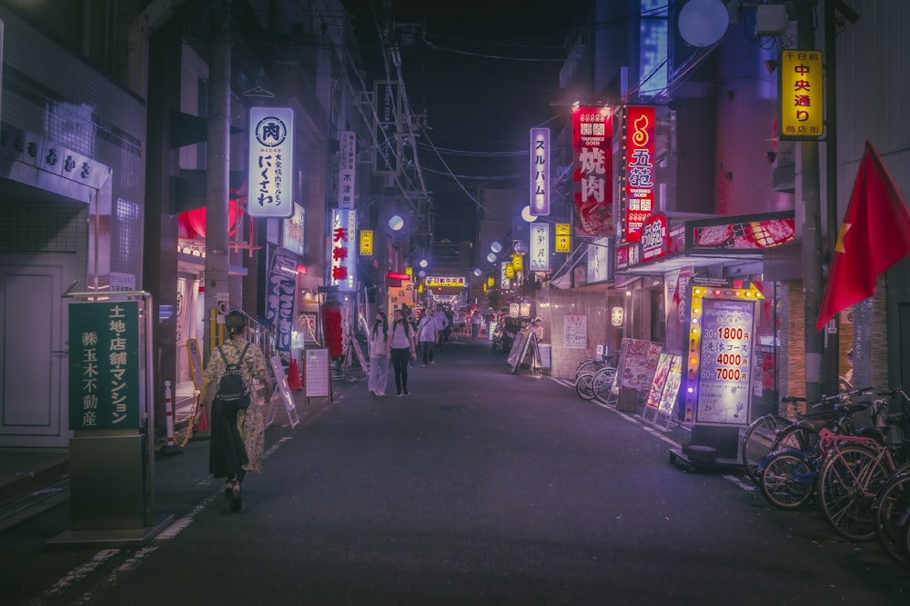 a woman walking down a street at night