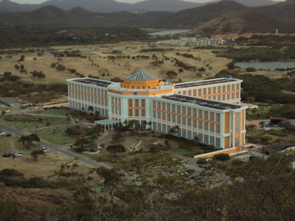 an aerial view of a large building with mountains in the background