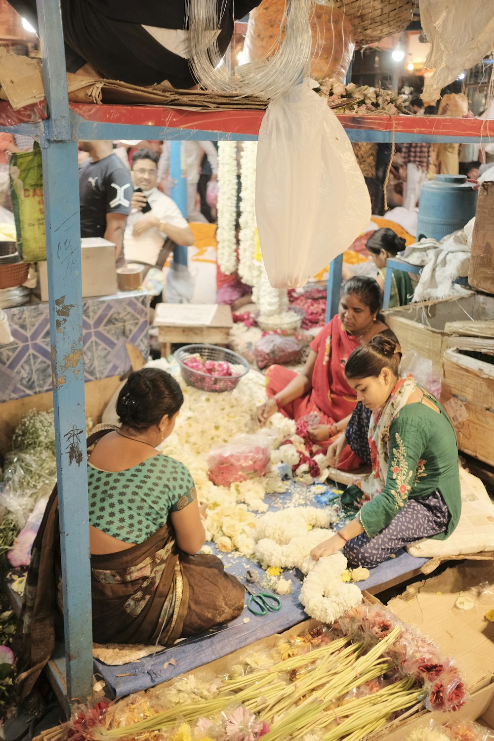 a group of women sitting on the floor of a market