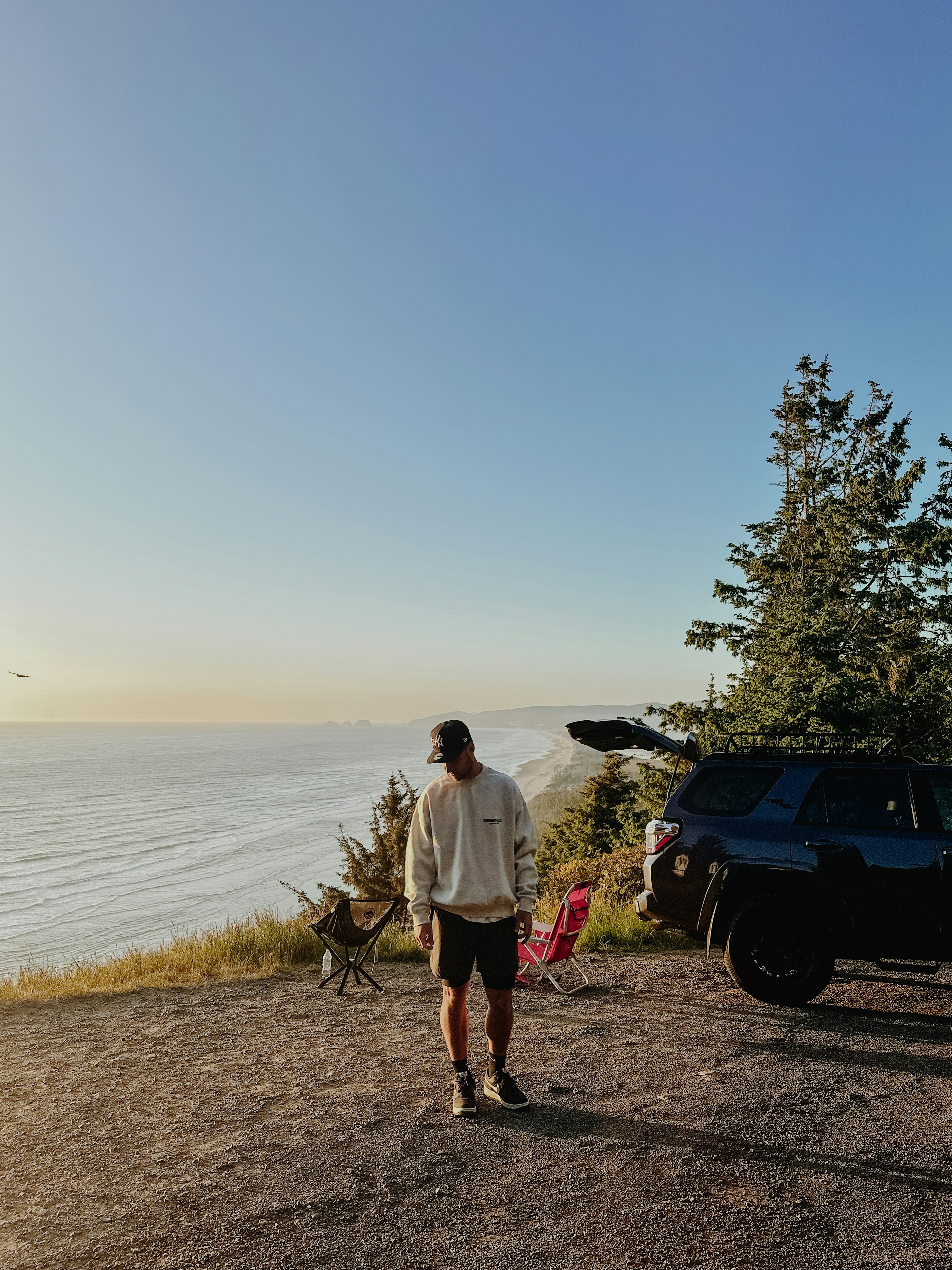 a man walking on a dirt road next to a car