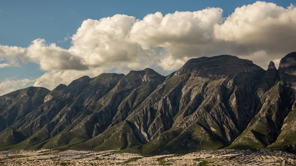 a mountain range with clouds in the sky