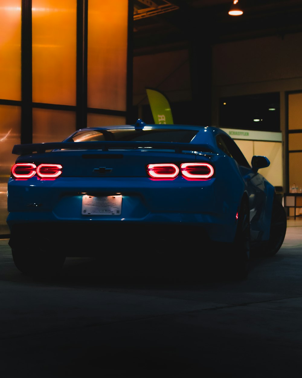 a blue sports car parked in front of a building