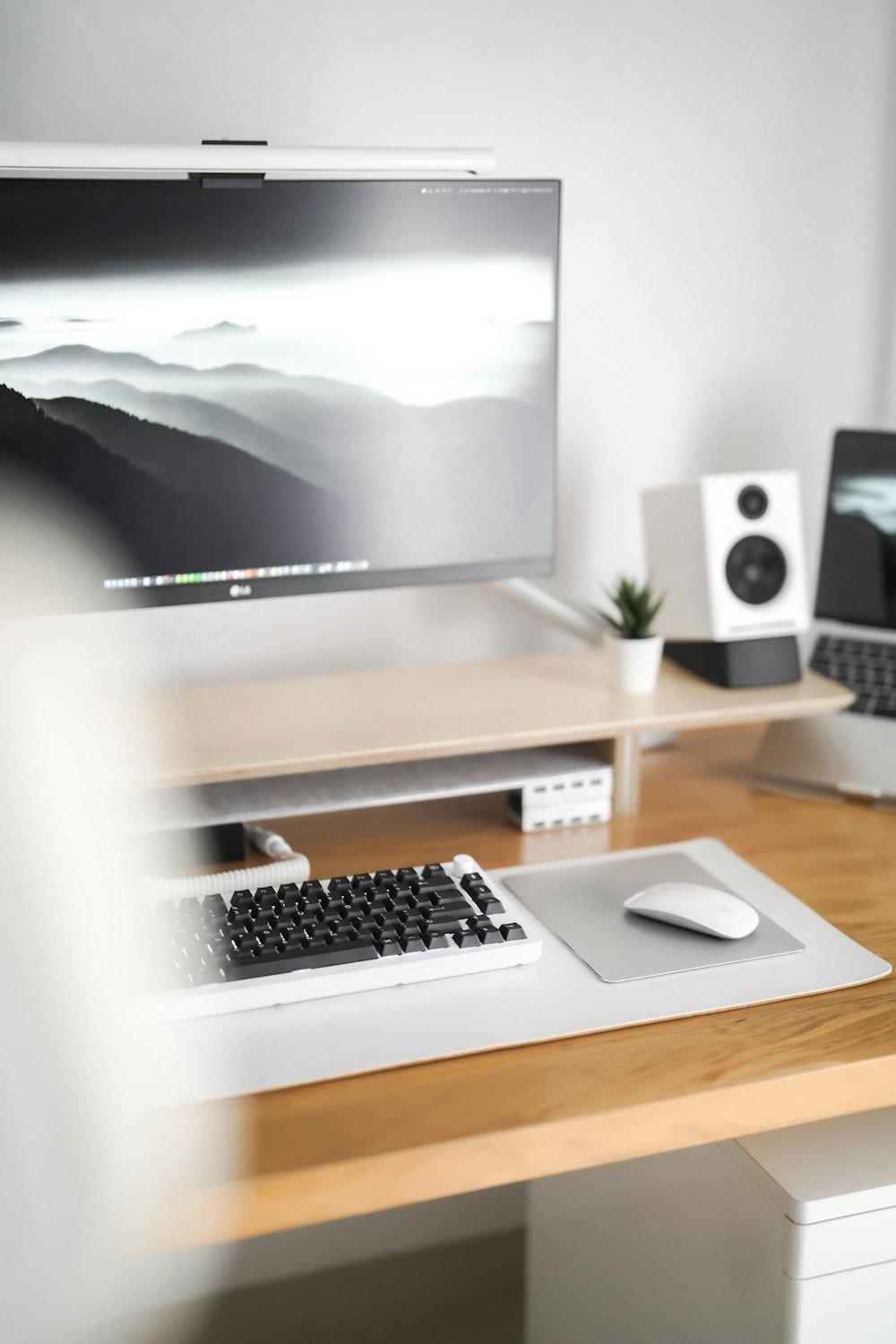 a desk with a keyboard, mouse and monitor on it