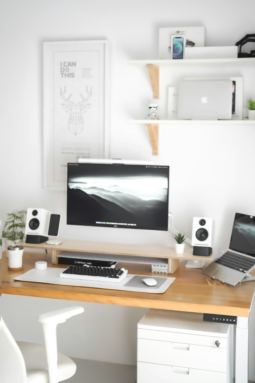 a desk with a computer and speakers on it