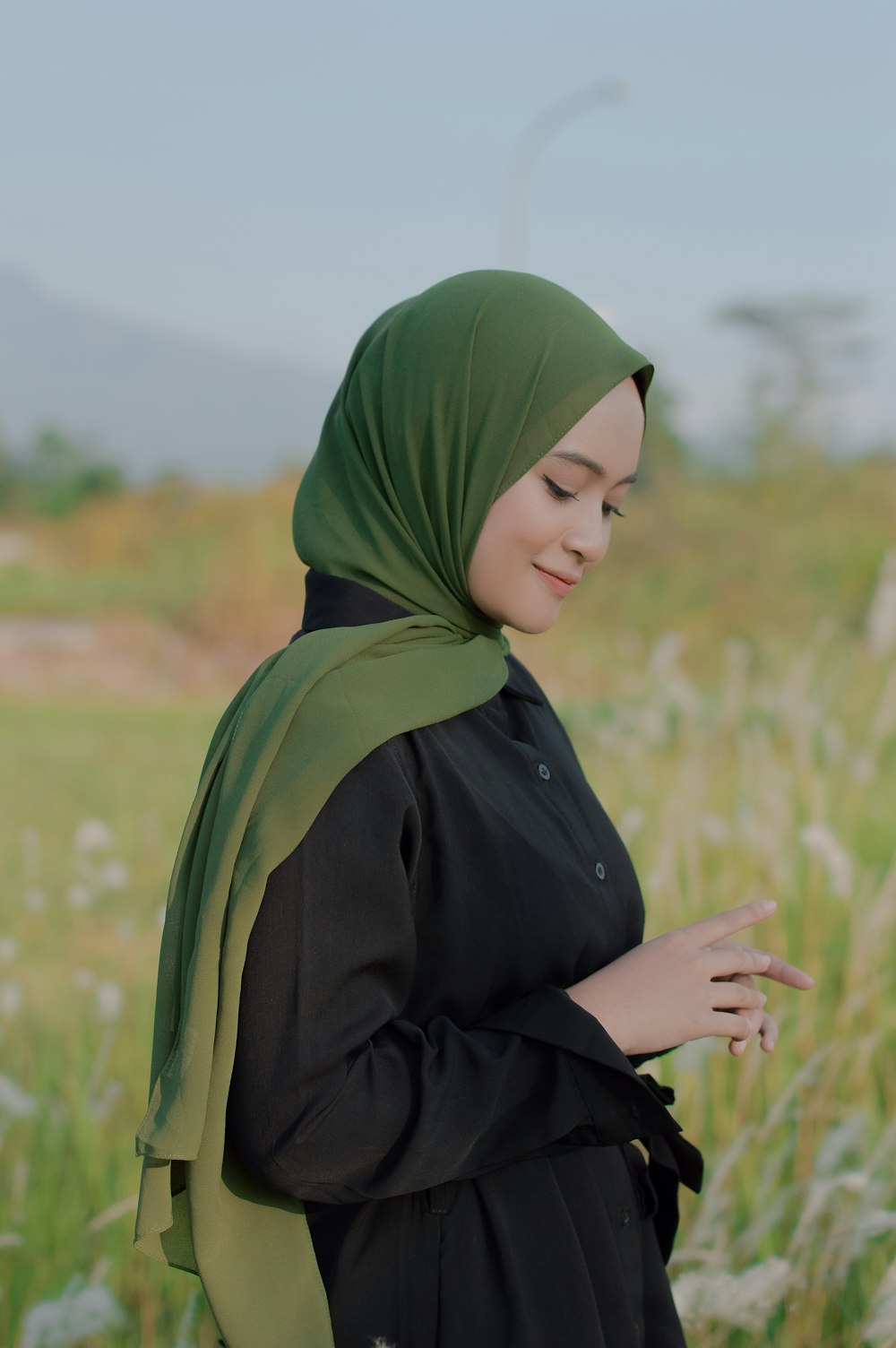 a woman standing in a field of tall grass