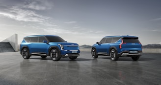 two blue suvs side by side in a parking lot