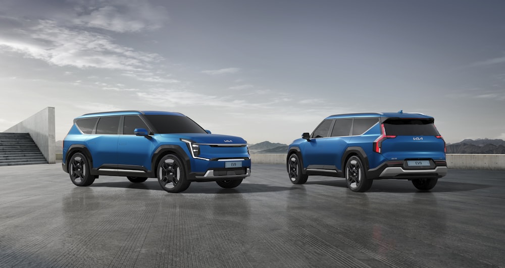 two blue suvs side by side in a parking lot