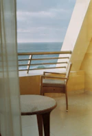 Private balcony overlooking the tranquil coastal waters and sandy beach below.