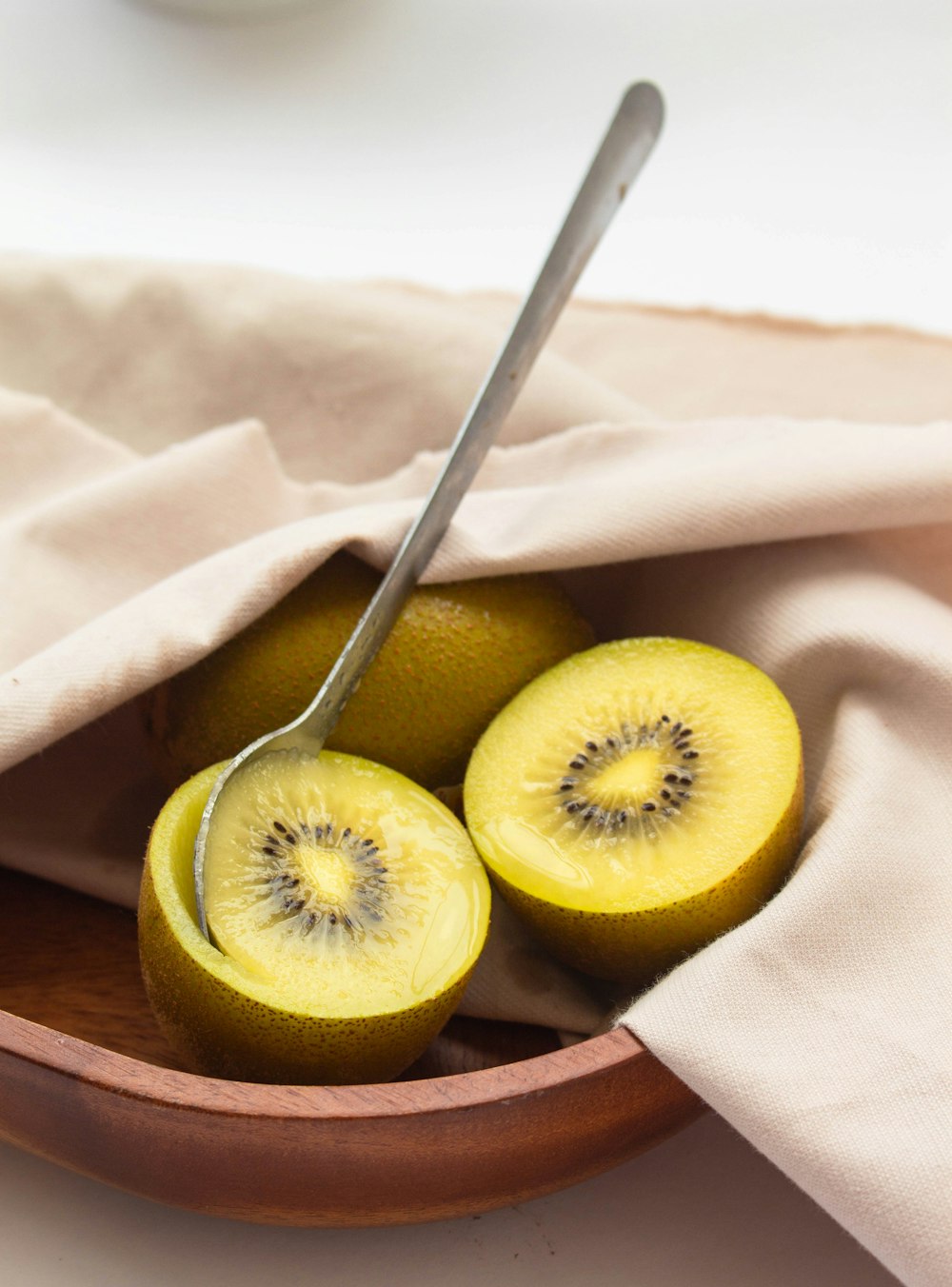 two kiwis cut in half in a bowl