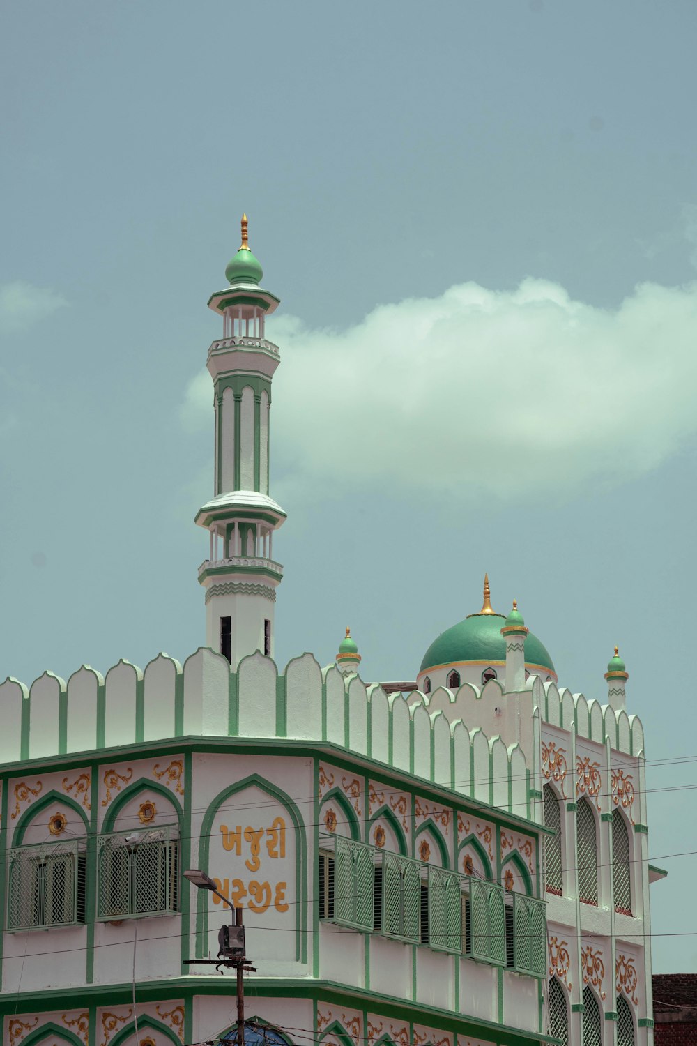 a large white and green building with a green dome