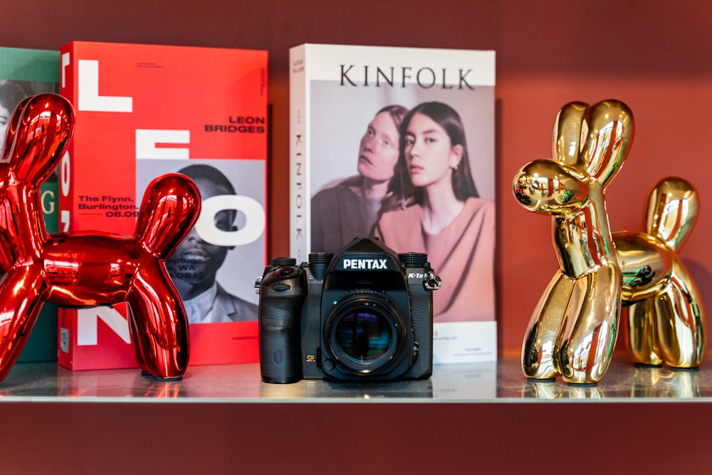 a camera and a balloon dog on a shelf