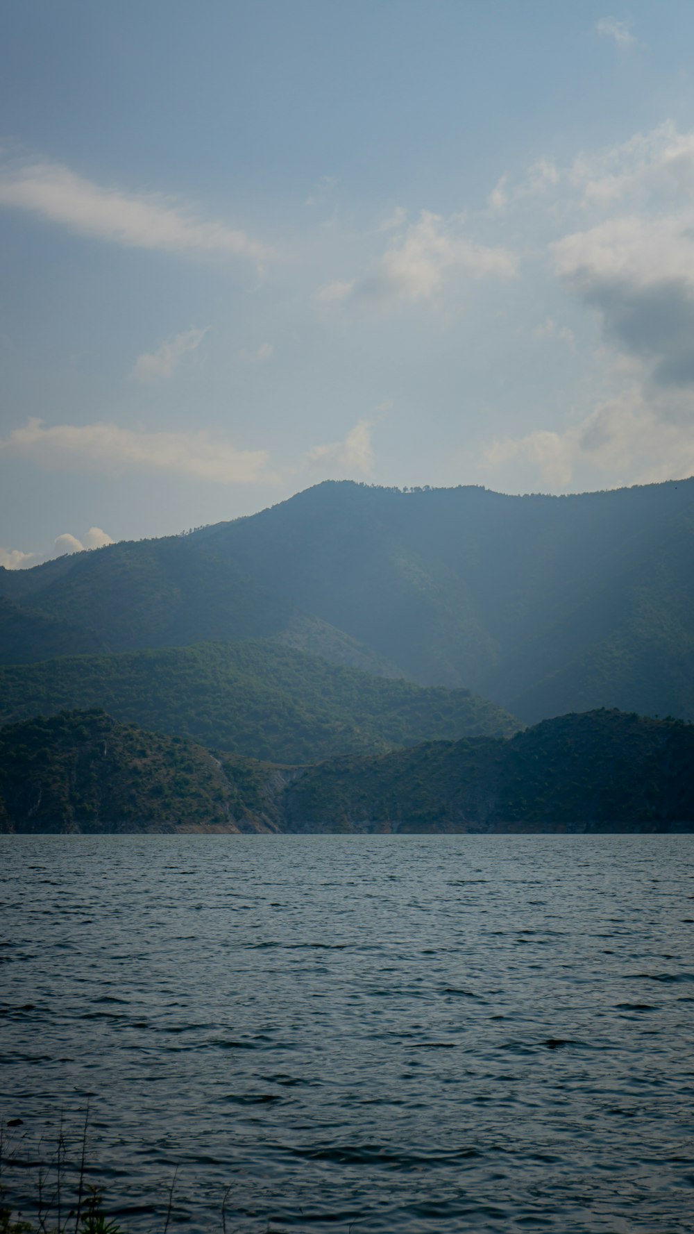 a large body of water with mountains in the background