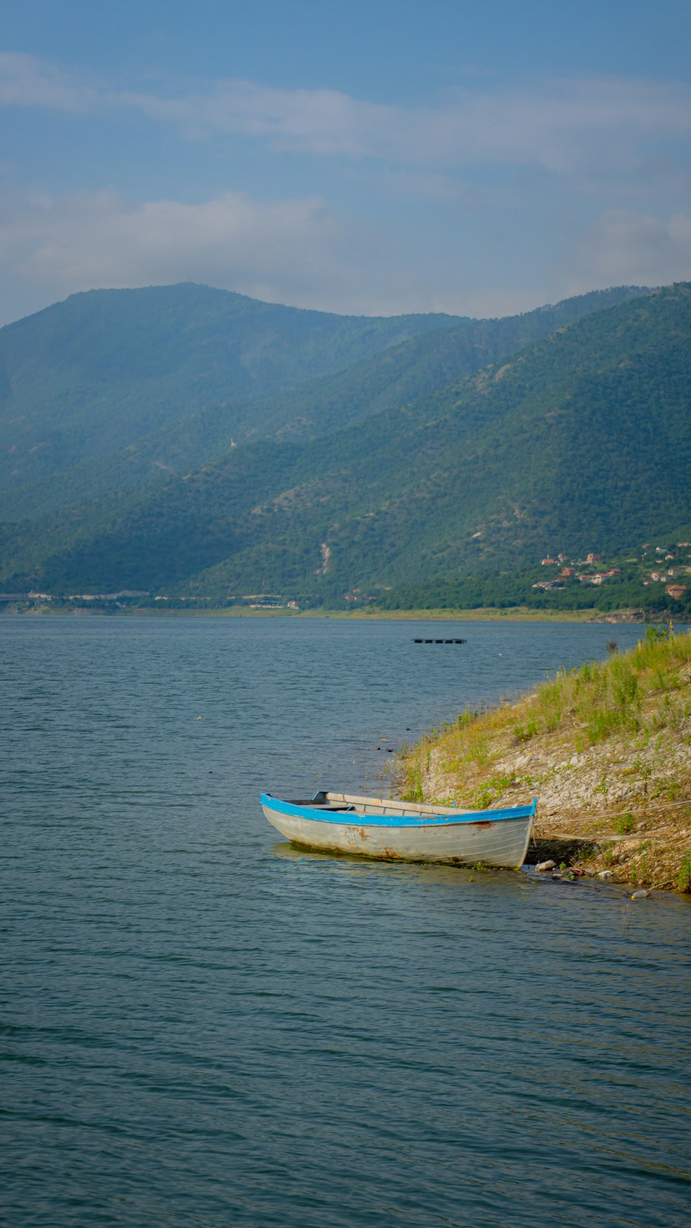 a small blue boat sitting on top of a lake