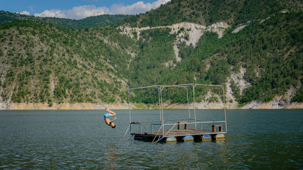a person jumping off a dock into a body of water
