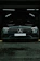 Elegant black luxury car parked in a pristine garage with golden accents.