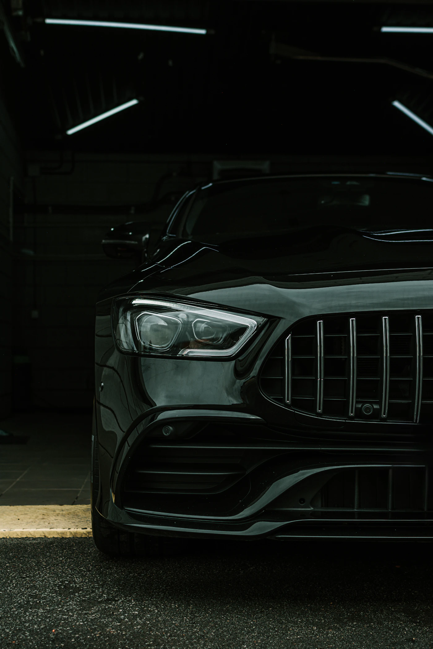 Black car parked inside a dark garage