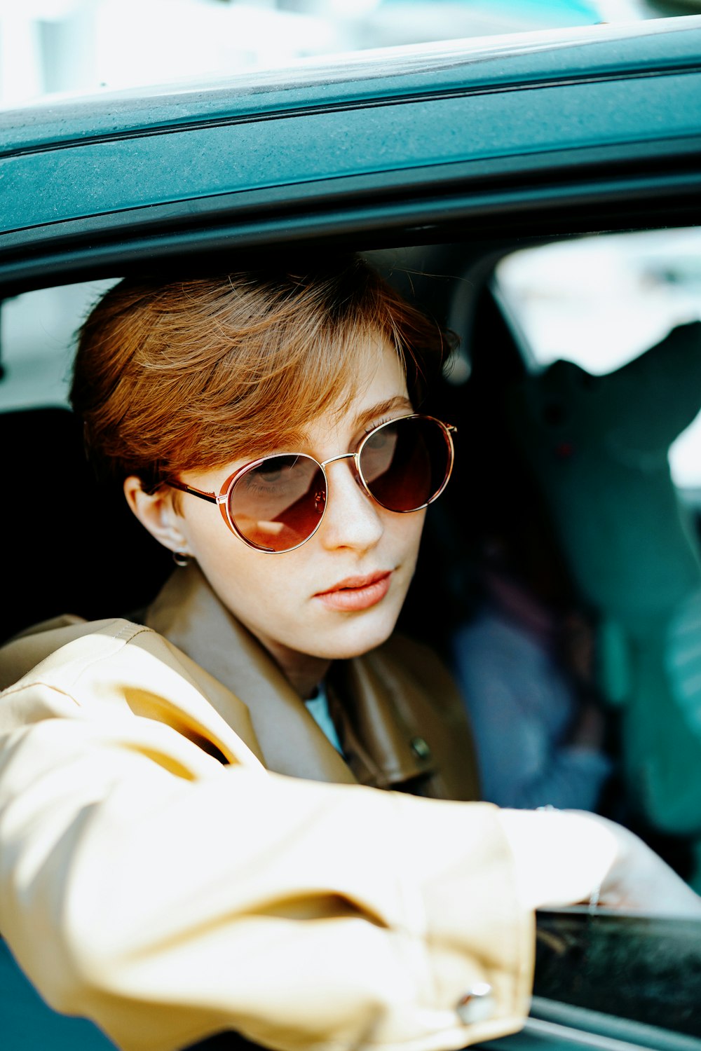 a woman wearing sunglasses sitting in a car