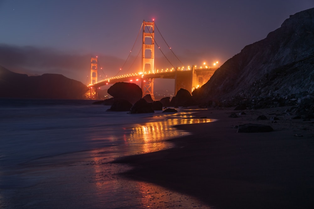 the golden gate bridge is lit up at night