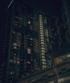 Luxurious high-rise residential building illuminated at dusk in Abu Dhabi.