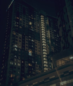 Evening shot of a luxury residential block with illuminated windows.