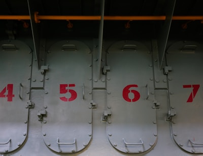 A row of sturdy metal doors lined up in the workshop, ready for delivery.