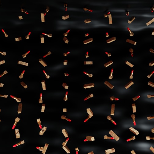 Close-up of vibrant MAC lipsticks arranged artistically against a sleek black and red animated background.