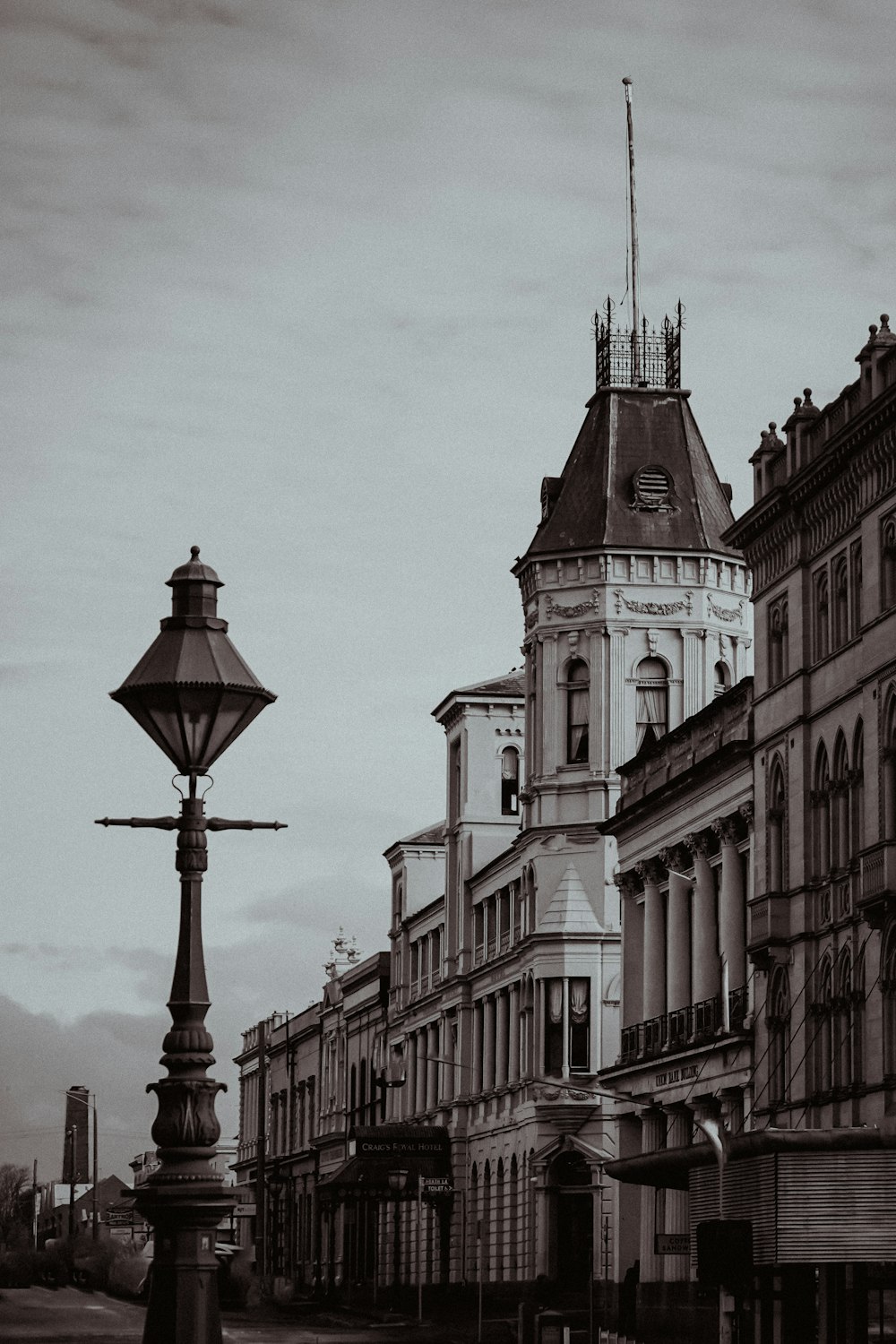 a black and white photo of a street light and buildings