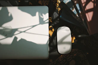 A close-up of the ultra-thin, foldable Cardxi mouse resting on a minimalist desk with soft ambient lighting.