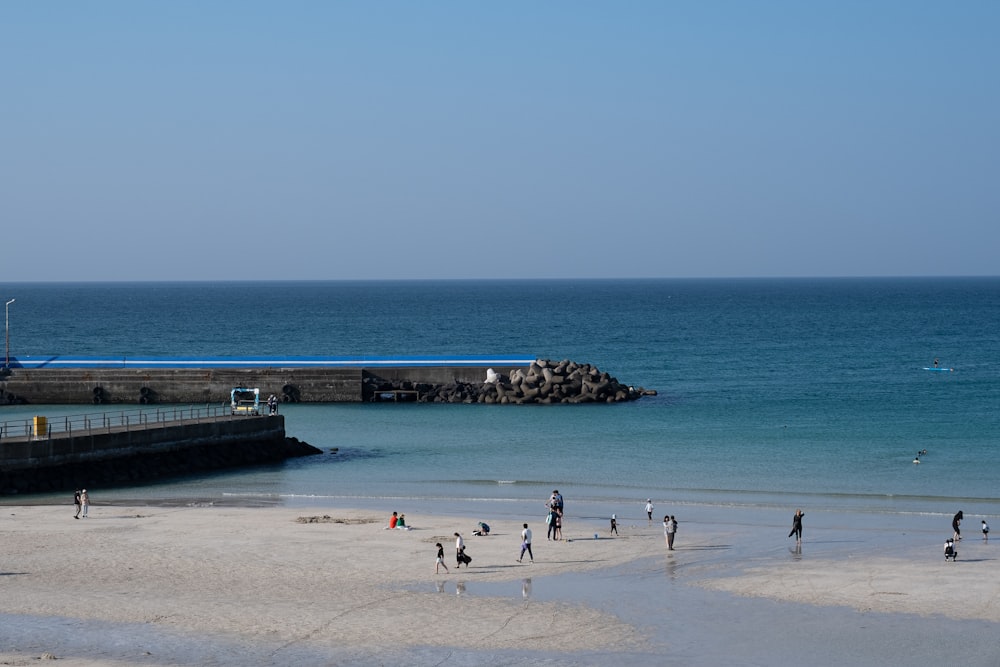 a group of people standing on top of a sandy beach