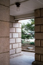 an open door leading to a patio with a tree in the background