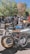 A group of motorcyclists wearing helmets and jackets, gathered around their bikes in a scenic location.