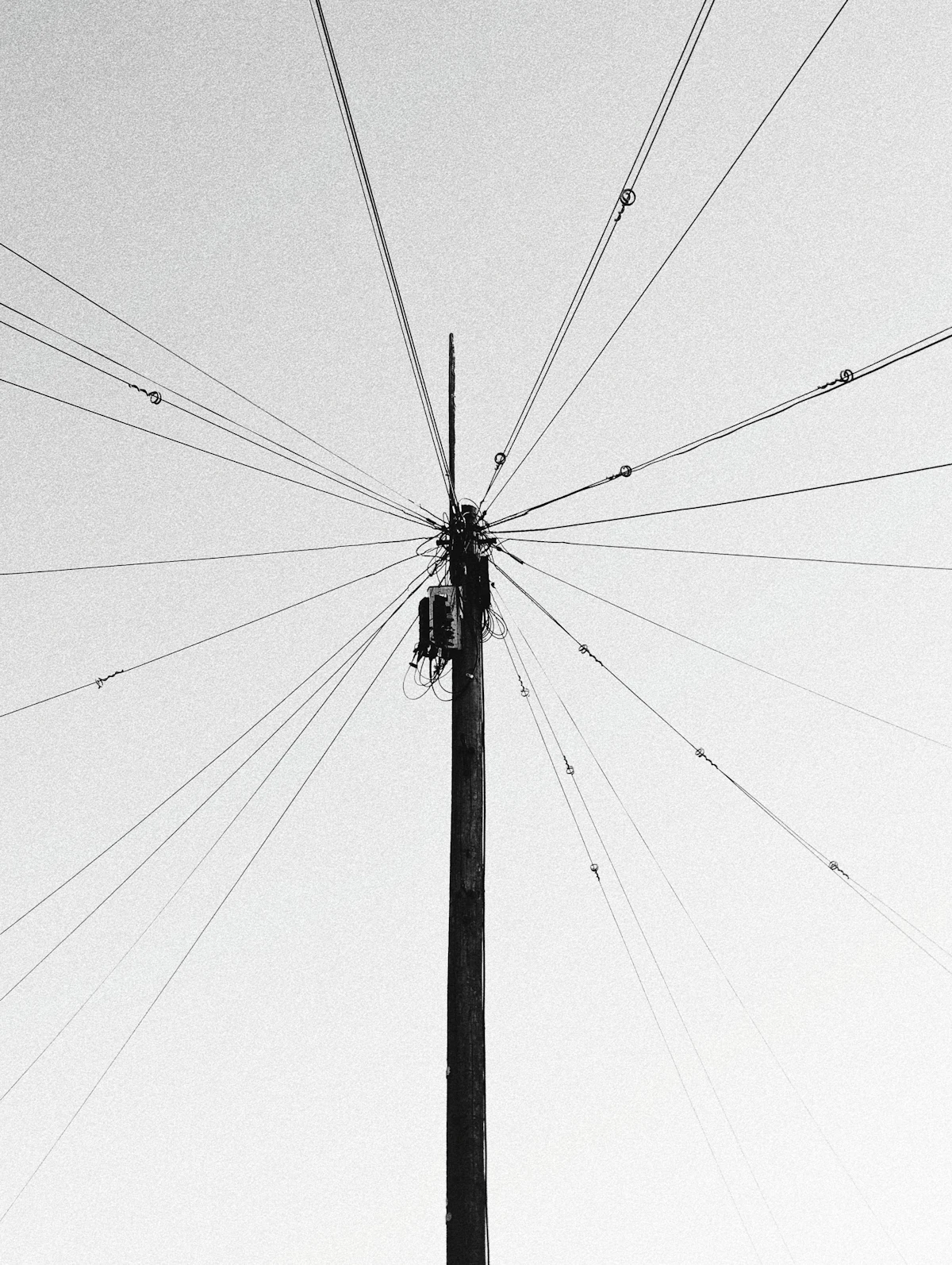 Discone radio antenna mounted on a mast against a pale sky